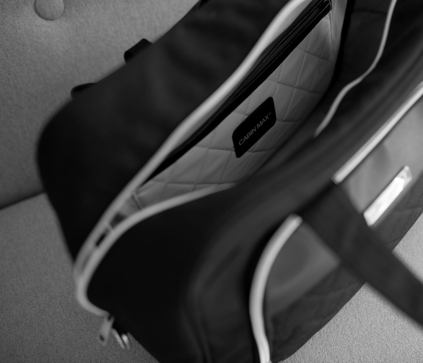 A picture of the inside Vela 24L Ladies Cabin Bag Holdall - 40x30x20 cm from CabinMax on a grey sofa in Spain. Airline -compatible with Ryanair.