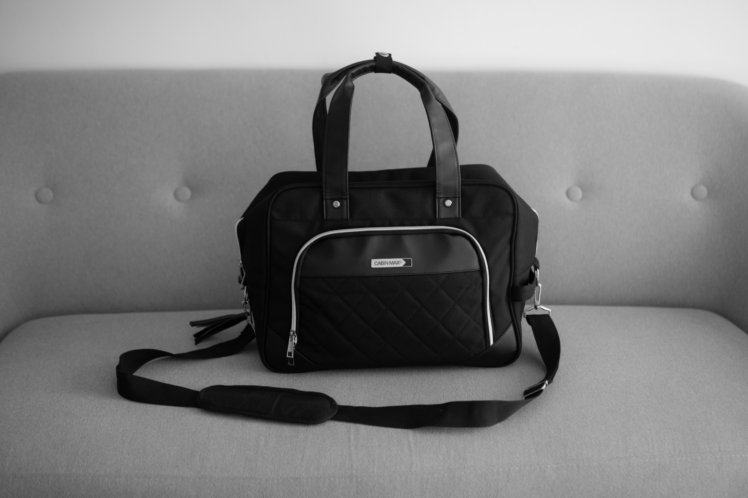 A picture of the CabinMax Vela 24L Ladies Cabin Bag Holdall - 40x30x20 cm, sitting on a sofa.