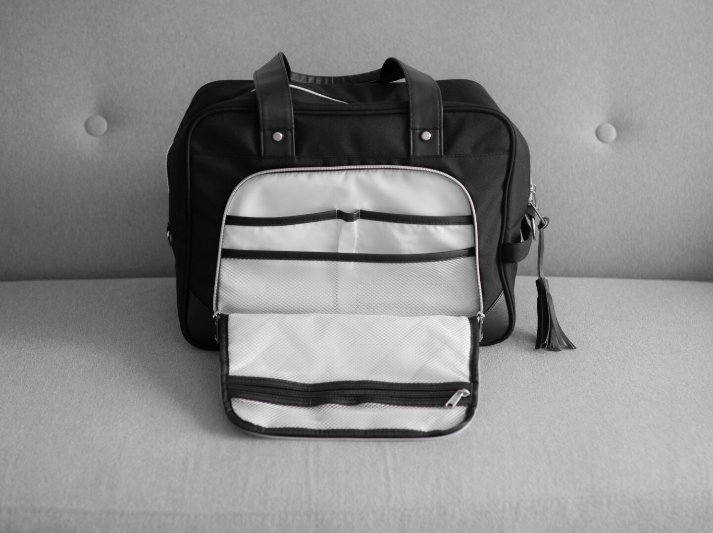 A picture of the inside Vela 24L Ladies Cabin Bag Holdall - 40x30x20 cm from CabinMax on a grey sofa in Spain. Airline -compatible with Ryanair.