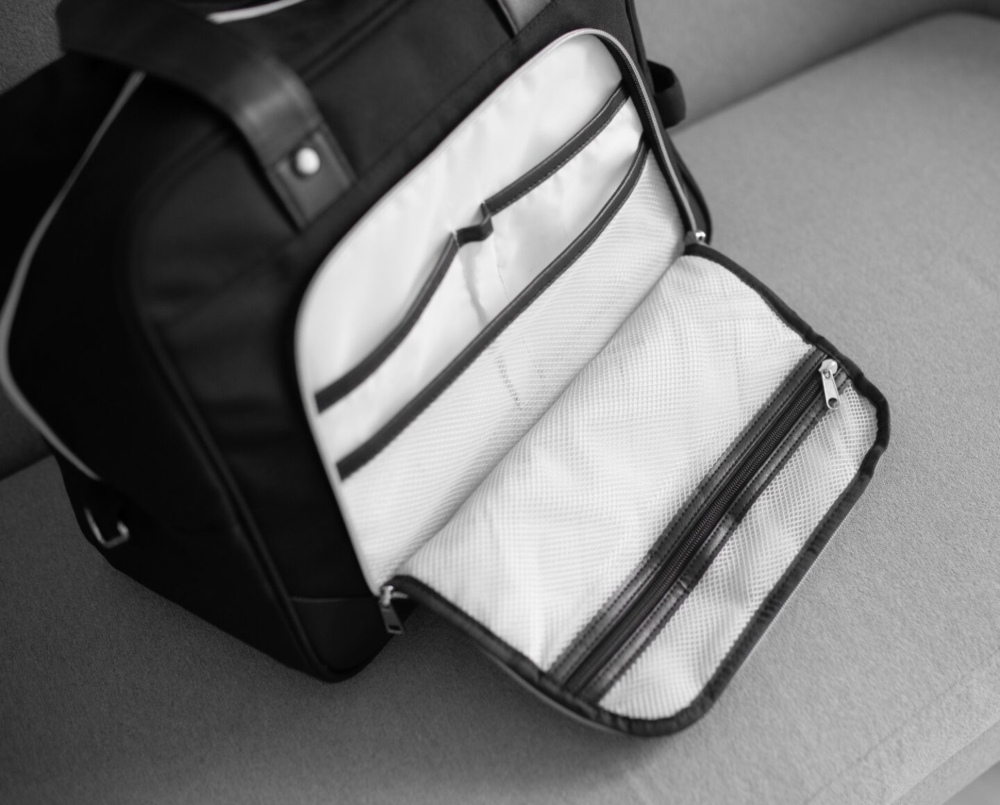 A picture of the inside Vela 24L Ladies Cabin Bag Holdall - 40x30x20 cm from CabinMax on a grey sofa in Spain.