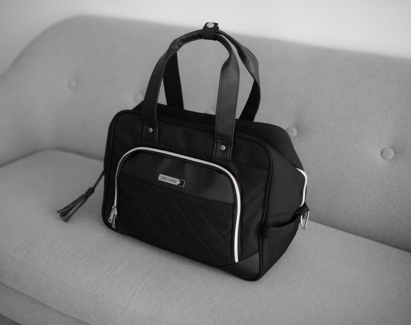 A picture of the inside Vela 24L Ladies Cabin Bag Holdall - 40x30x20 cm from CabinMax on a grey sofa in Spain. Airline -compatible with Ryanair.